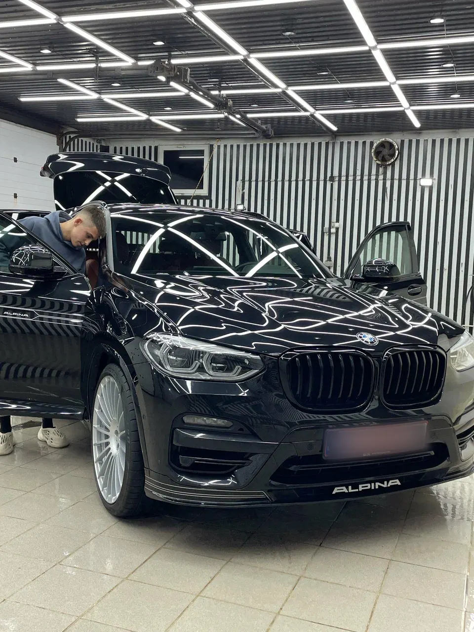 Глянцевый чёрный BMW Alpina XD3: в капоте отражаются лампы студии