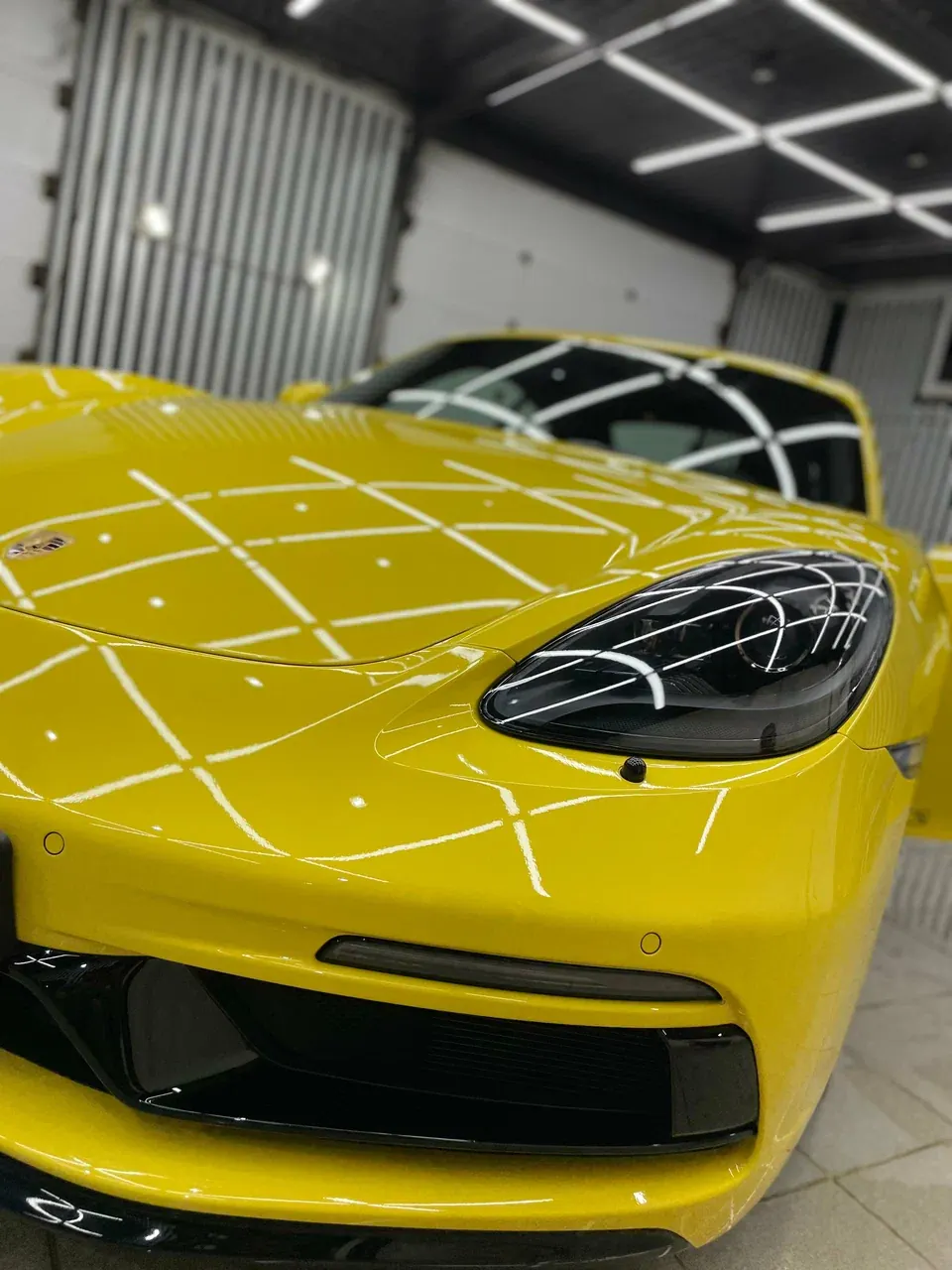Жёлтый Porsche 718 Cayman: отражение светодиодной сетки на капоте и фаре